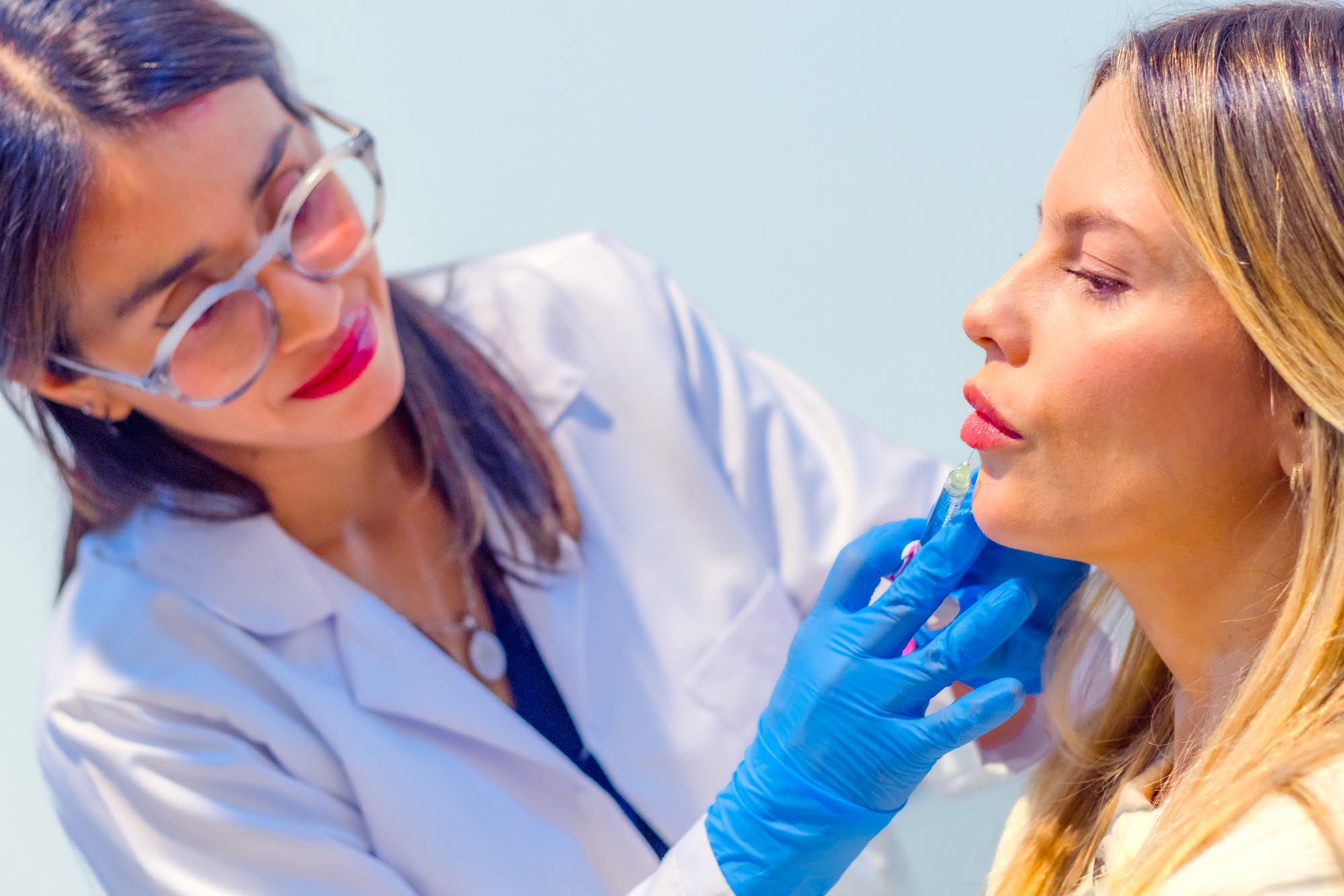 Especialista de Skin Plus Bogotá aplicando un tratamiento inyectable facial a una paciente
