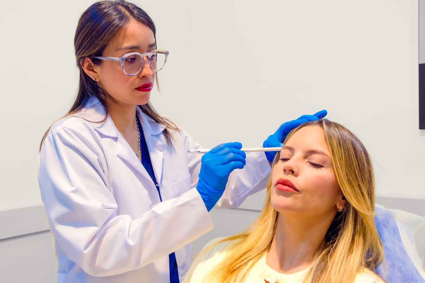 Médica de Skin Plus marcando los puntos de aplicación de bioestimuladores en el rostro de una paciente