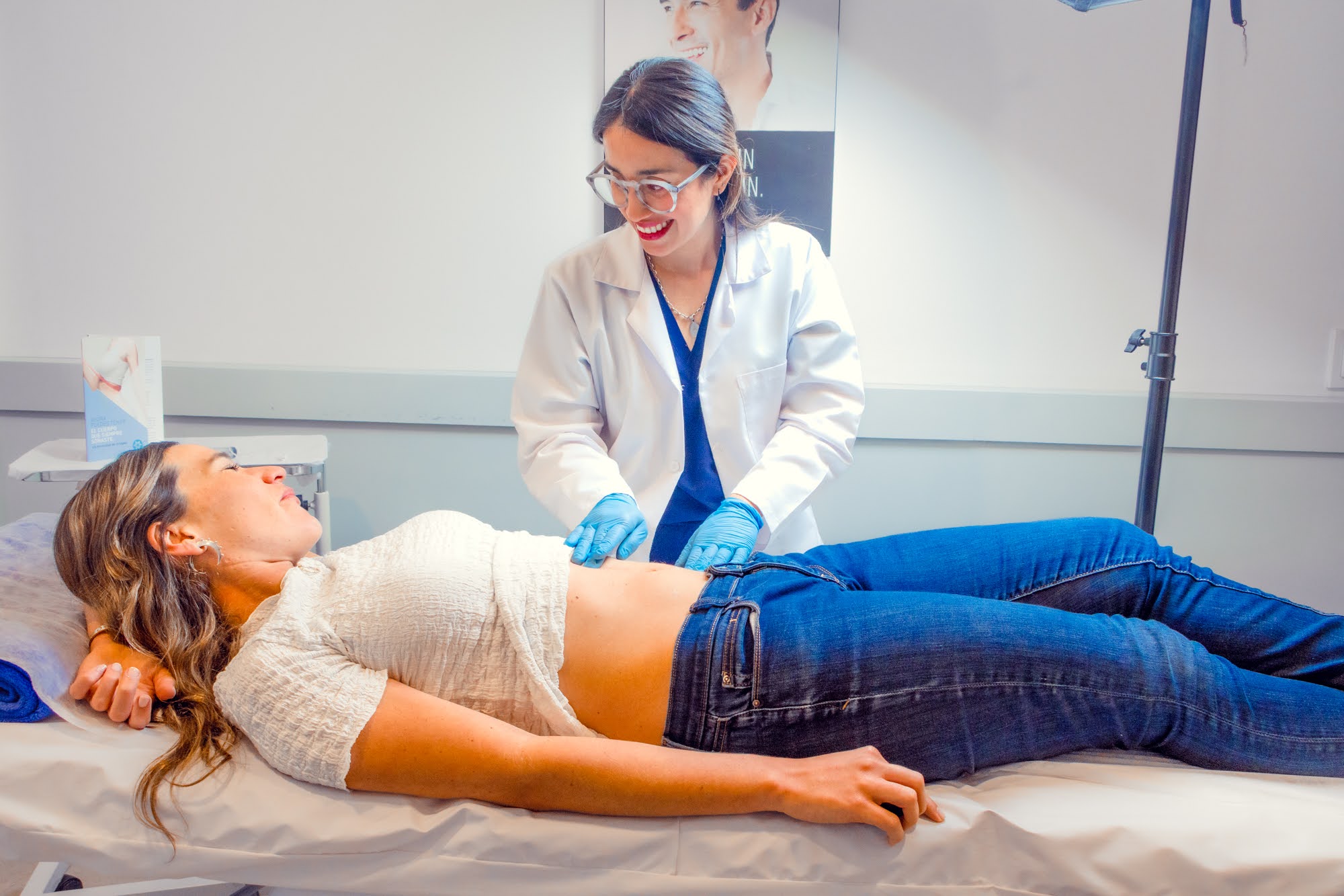 Médica de Skin Plus revisando la zona de abdomen de una paciente antes de una sesión de criolipólisis