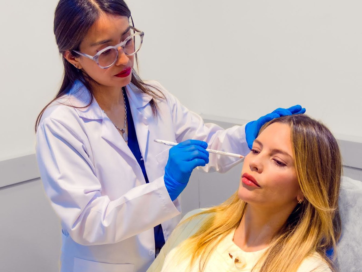 Médica de Skin Plus valorando el rostro de una paciente antes de aplicar Profhilo