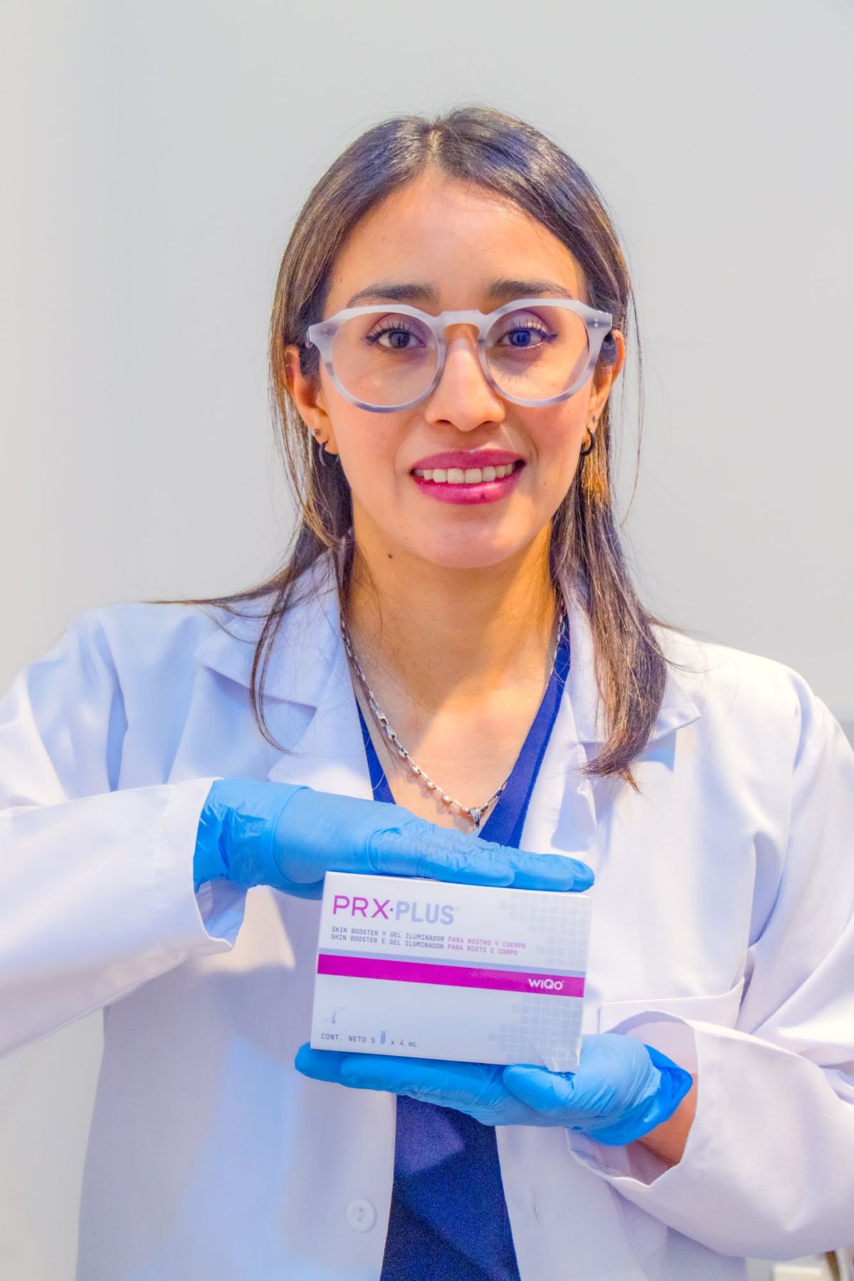 Especialista de Skin Plus Bogotá sosteniendo la caja de PRX PLUS