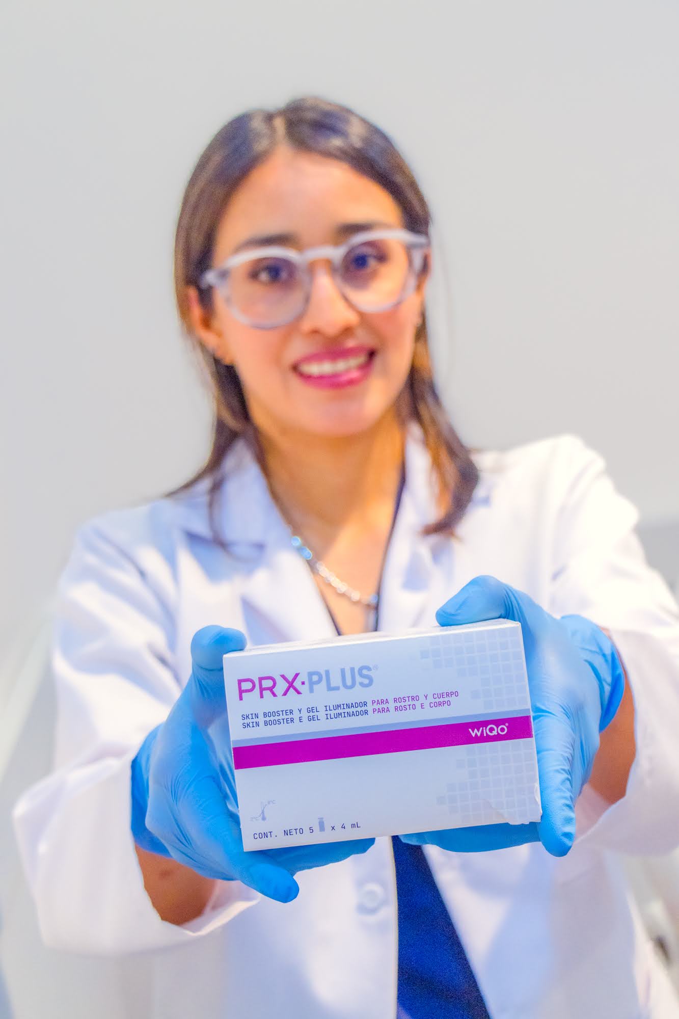 Especialista de Skin Plus Bogotá mostrando la caja de PRX PLUS skin booster